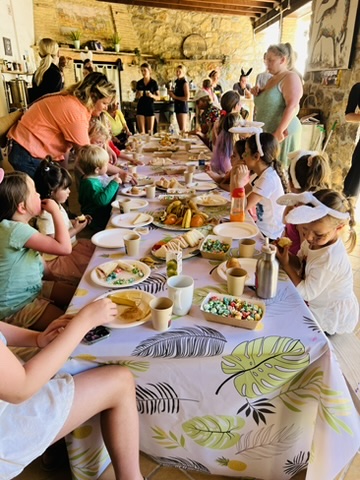 Children sharing a birthday lunch at the long party table at Paradise Stables