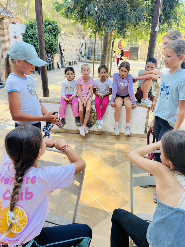 Group of children in a shaded theory session learning to handle a lead rope at Paradise Stables