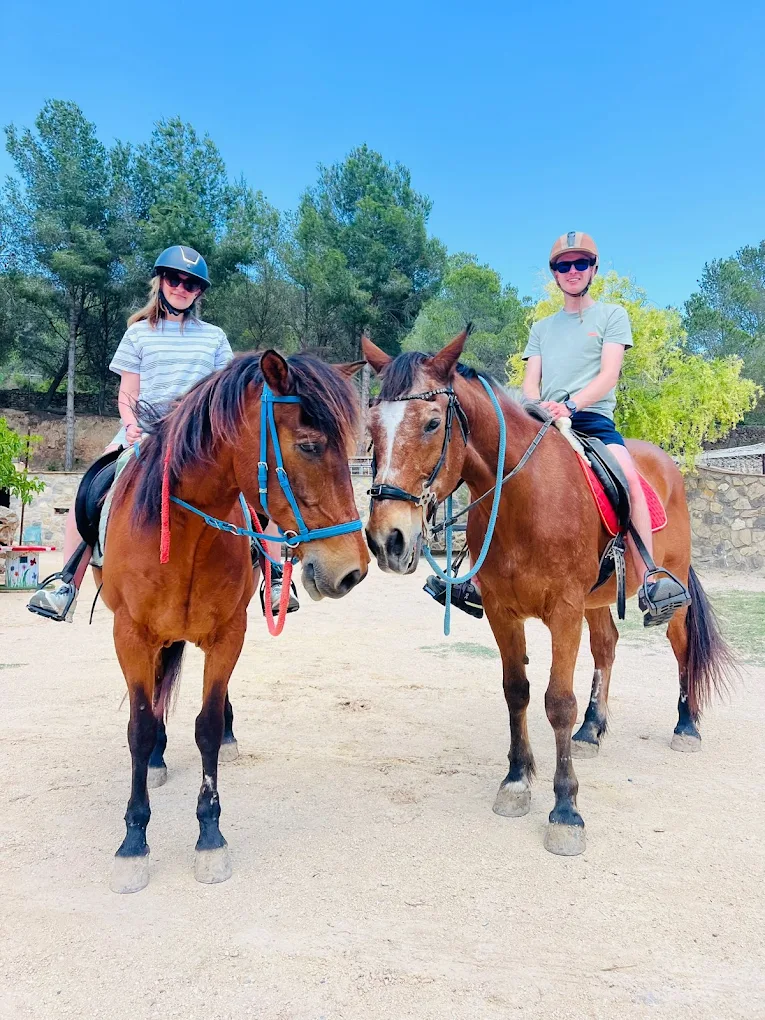 Two riders together in the arena at Paradise Stables