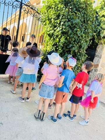 Children in tutus and costumes lined up by the gate at a themed Paradise Stables party