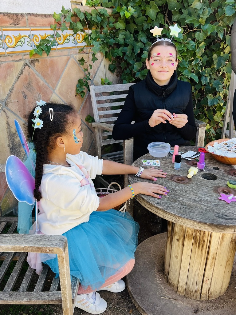 Child in fairy wings having her nails painted at a Paradise Stables party
