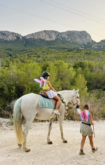 Fairy child on a white unicorn with mountain views near Calpe