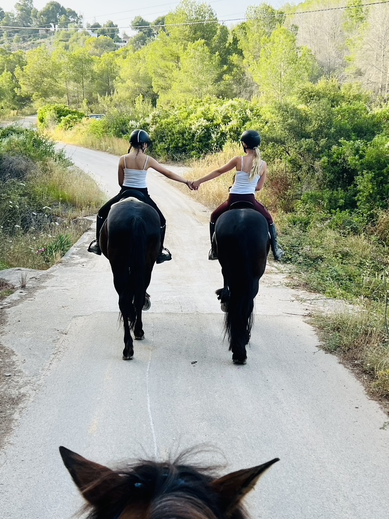 Two riders hacking out side by side on quiet country lanes near Paradise Stables